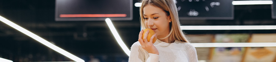 Mulher segurando uma fruta cítrica.