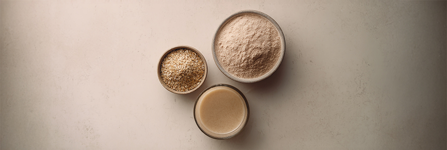 Oats, oat flour, and oat milk in bowls.