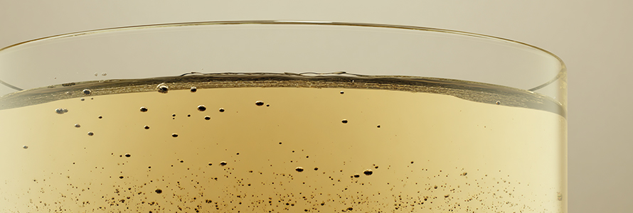 Close-up of a sparkling golden beverage in glass.