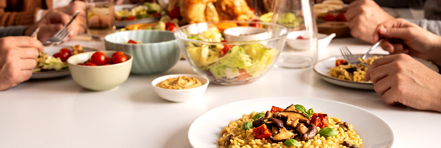 Grupo almoçando risoto de cogumelos com salada e petiscos