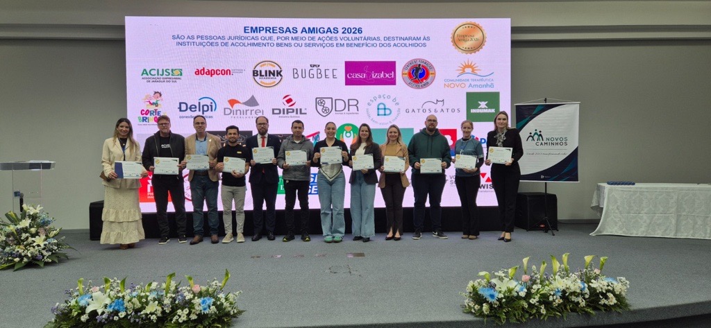 A imagem apresenta a entrega da certificação de Empresa Amiga reconhece a participação da DR em ações de voluntariado e relacionamento com a comunidade.
